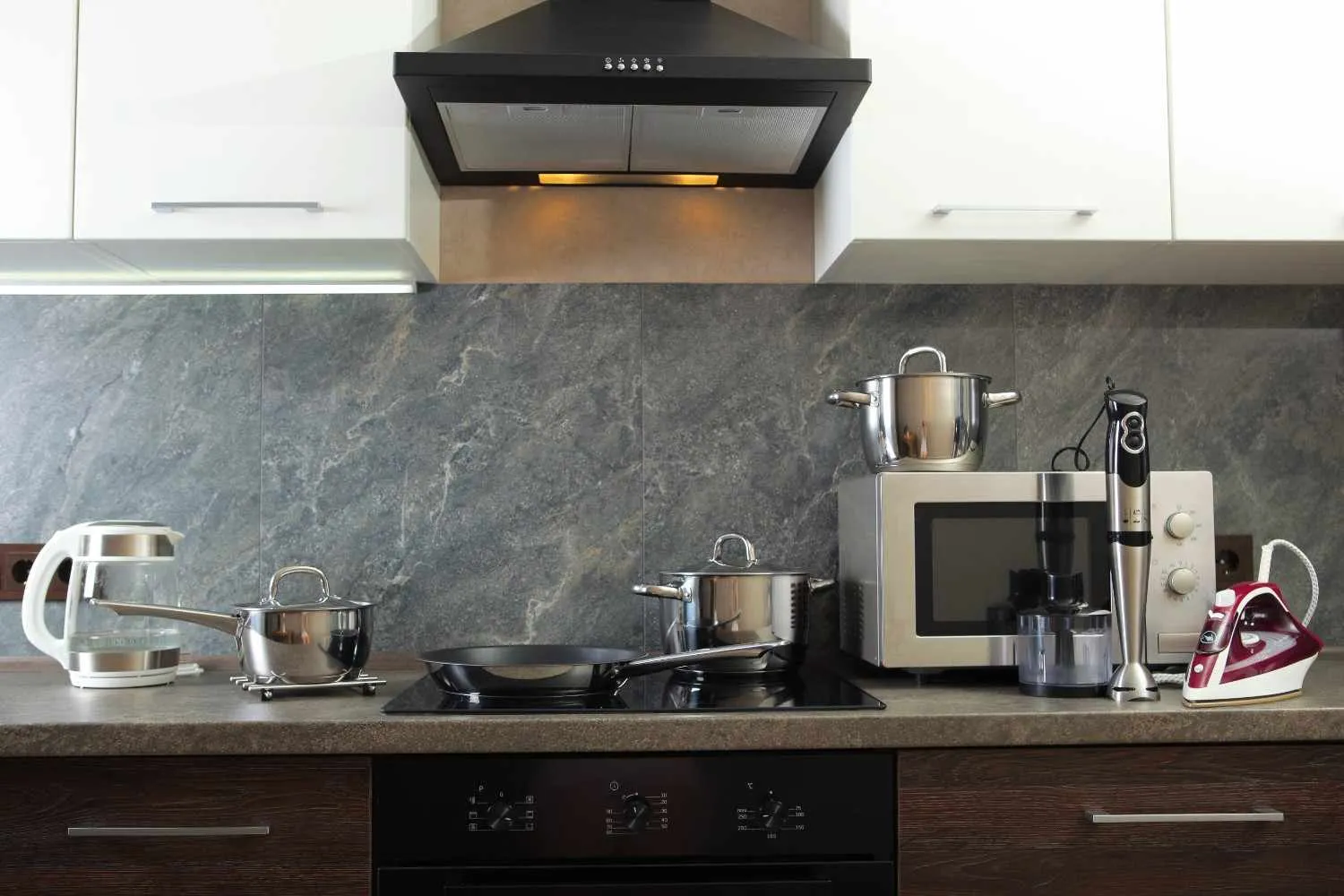 Kitchen counter with a cooktop, range hood and microwave